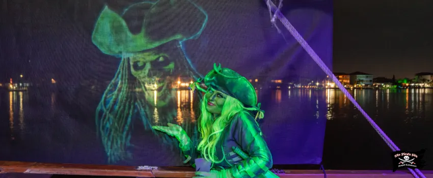 SST - A green pirate woman next to a projector